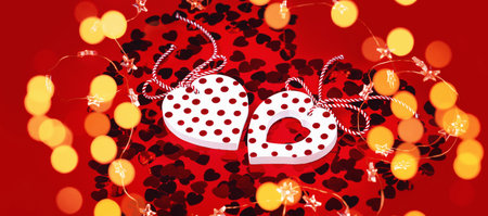 Two white heart pendants golden lights. St Valentines Day greeting card banner or Mother's Day....