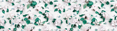 Spring pattern. blooming with white and pink flowers fruit tree branches on white wood. Flat lay full frame, freshness concept for invitation or celebration bannerの写真素材