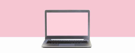 Laptop. Mockup screen on white desk and plain pink background banner. Distant learning. working from home, online courses or support minimal concept. Banner with copy spaceの写真素材