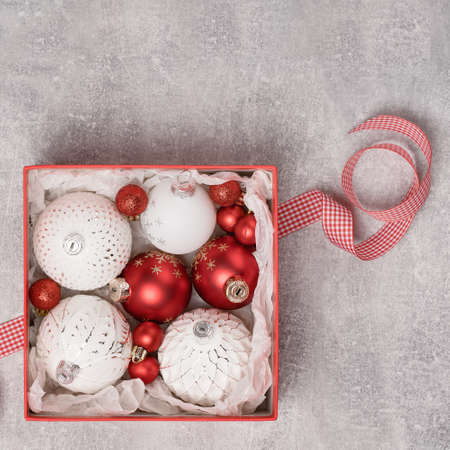 Red and white Christmas baubkes in a box with checked ribbon flat lay. Mery Christmas and Happy New Year seasons greetings cardの写真素材