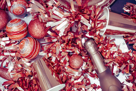 Golden red Merry Christmas and New Year tinsel and baubles background with Sparkling wine bottles...