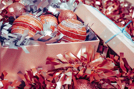 Golden red Merry Christmas and New Year tinsel and baubles background with Gift box. top view...
