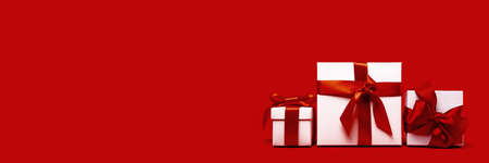 set of tree assorted red and white gift boxes on red background. different size. Merry Christmas and Happy New Year gift shopping and sale concept. St Valentines Day or birthday gift. Minimal edgelessの写真素材