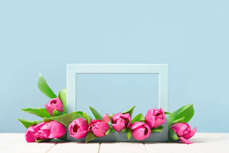 Bunch of pink tulips in a frame on wooden table. Banner with copy space, Birthday gift. Valentines 8 March Women's or Mothers Day celebration greeting card or framed web floral. Springの写真素材