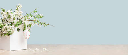 Happy Easter. Easte egg on spring festive blooming with white flowers fruit tree branches in small...