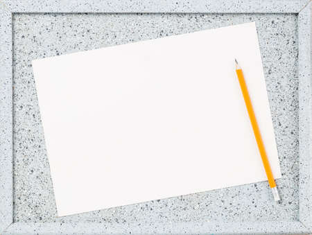 Mockup. Blank paper page on grey cork notice board with yellow pencil close up. Copy space. Advert or reminder template. Opening or closing hours.の写真素材