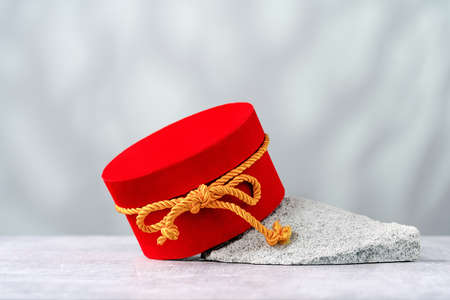 Red round gift box with golden ribbon on a rock gray background. Gift or holiday concept. Mothers Day, birthday wedding or St Valentines day banner with copy spaceの写真素材