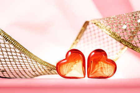 A roll of golden gift ribbon with two hearts for St Valentines day 14 February.の写真素材
