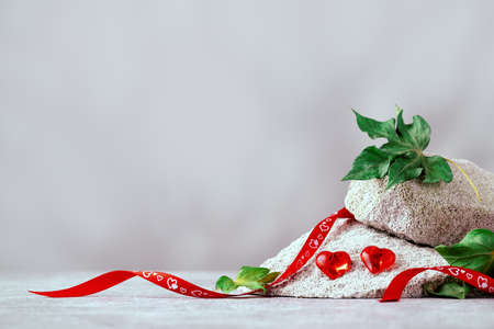 two red glass hearts on gray stones bannerの写真素材