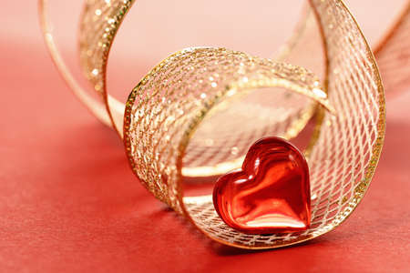 A roll of golden gift ribbon with heart for St Valentines day or 14 February.の写真素材