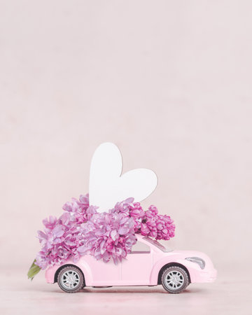 lilac flowers on top of retro pink car with heartの写真素材