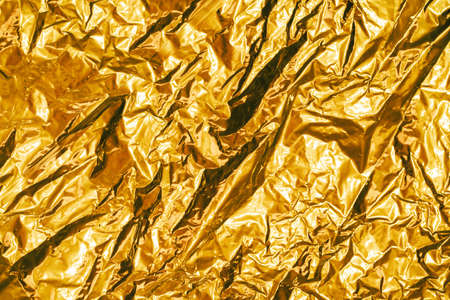 creased metal foil sheet in trendy golden colorの写真素材