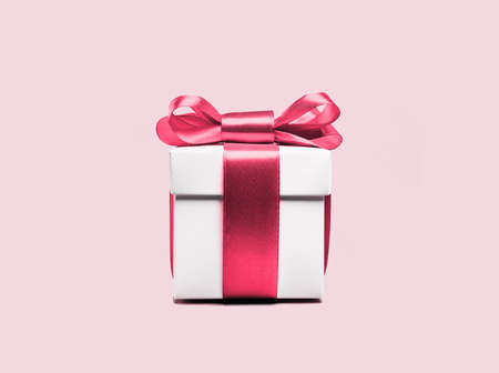 Pink gift box with pink ribbon on pink backgroundの写真素材