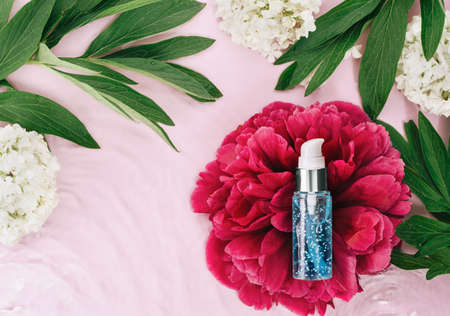 Cosmetics spa serum bottle on water waves and flowers