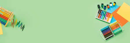 Color paper, paint and school stationery on green desk