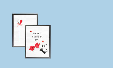 Happy Fathers Day text on letter boards with two bow ties, big and smal red and blue and a heart on...
