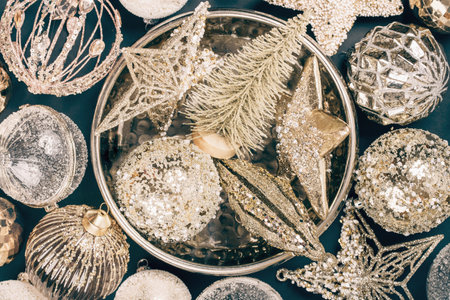 Merry Christmas and Happy New Year rich golden and crystal festive ornaments. stars glitter and Christmas trees in round golden tray plate on teal green. Party decor centered. Top view full frameの写真素材