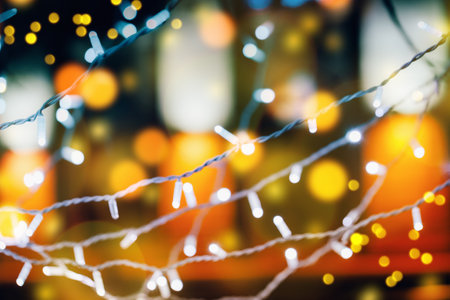 City lights defocused. Selective focus on Christmas decorations illuminated at night. Merry...