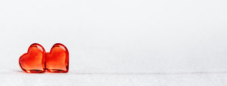 Two red glass hearts together for St Valentines day or 14 February. Minimal wide banner with copy space. Love or wedding engagement conceptの写真素材