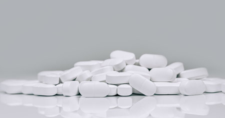 Medical background of many capsule tablets or pills on white table. Close up. Healthcare pharmacy...