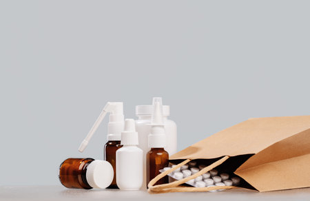 Online pharmacy. prescription drugs and over the counter medication ready for delivery to customers. Pills and spray white mockup containers and buff paper bags on table. Drugstore shoppingの写真素材