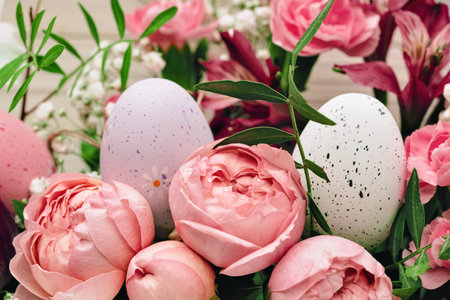 Easter eggs with beautiful rich bouquet of spring flowers on wooden background. Happy Easter full frame pink flowers closeupの写真素材