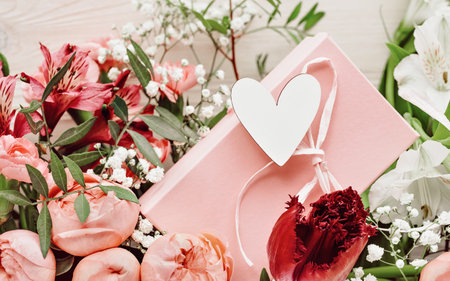 Spring or summer pink and white garden flowers full frame background. Heart and pink gift box greeting card. Carnations hyacinth roses alstroemeria primrose floral arrangement.の写真素材