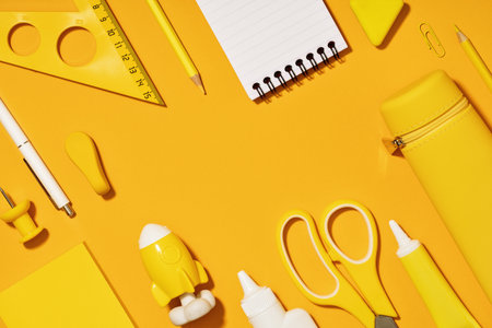 Assorted office and school white and yellow stationery. copy space for back to school or education craft office work concept. Bright Yellow monochrome scissors, rocket notepad. Achievement and successの写真素材
