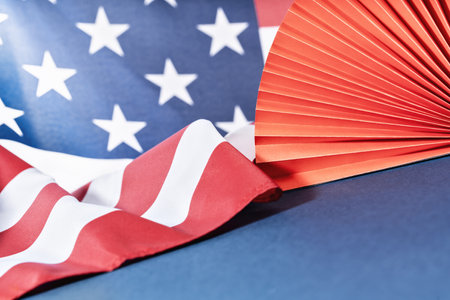 4th of July. US American flag and red rosette on blue festive background. Happy Independence Day. Stars and stripes. Copy space.の写真素材