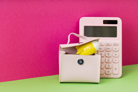 Yellow rocket on desk in pink briefcase with calculator on magenta background. copy space for back...