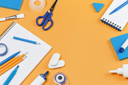 Assorted office and school white and blue stationery on bright yellow background. Organized knolling for back to school or education and craft concept. Selective focus. Copy spaceの写真素材
