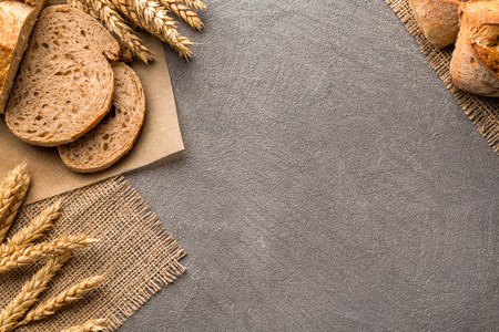 Bread border on dark wood with copy space background, top view. Bakery, cooking and grocery store concept.の写真素材