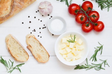 Bruschetta ingredients with mozzarella, cherry tomatoes and fresh garden rosemary, top view, copy spaceの写真素材