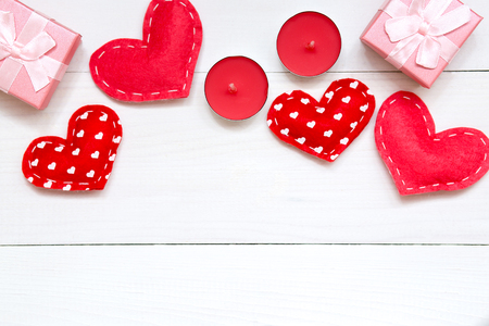Red hearts, gift and candles on white wooden background, concept for Valentines day, copy space, top view.の写真素材