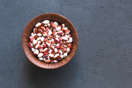 Bowl of different haricot beans on the stone table, top view, copy spaceの写真素材