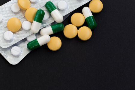 Pharmacy background on a black table. Medicine and healthy, close up of capsules. top view, copy space.の写真素材