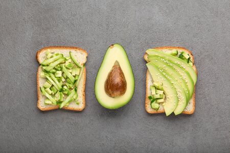 Variety of healthy breakfast sandwiches with avocado and toppings, top view. Avocado toasts, healthy...