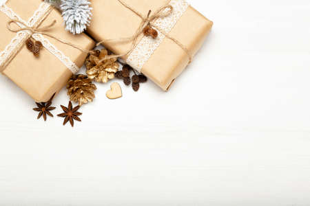 Christmas composition, Christmas gifts, golden pine cones on white wooden background copy spaceの写真素材