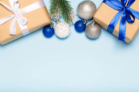 Christmas blue background with decorations, gift box and fir branches top view copy space