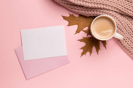 Autumn cozy composition, cup of coffee, paper blank, pink pastel plaid on pink background. Fall concept. Flat lay, copy space.の写真素材