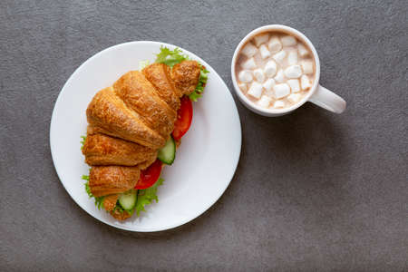 Vegan croissant, sandwiche on a stone table, croissant with vegetables and greens, concept of vegan cuisine. Healthy vegetarian breakfastの写真素材