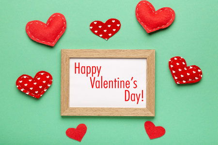 Happy valentine's day card, frame and red hearts on green background, top viewの写真素材