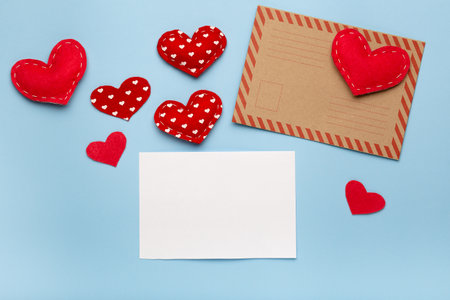 Valentine's day love letter flat lay. Envelope white card and hearts on blue background copy space top viewの写真素材