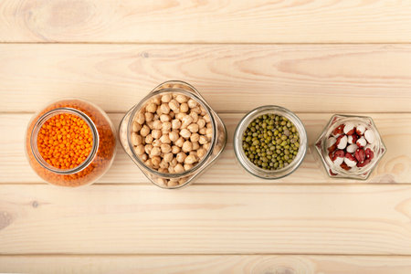 Food storage. Food ingredients in glass jars and tins on wooden table top view, copy space. Preservation concept.の写真素材