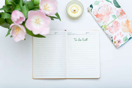 Girls to do list, spring composition. Notebook with to do list on white table top view