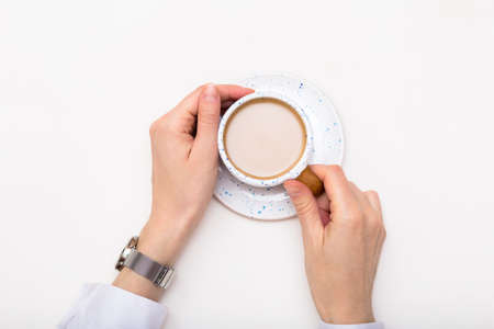 Female hands holding coffee cup at coffee break top view copy space, breakfast coffee or milk tea concept.の写真素材