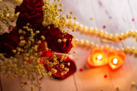 two red burning burning candles hearts flowers bow close up pearls romantic backgroundの写真素材