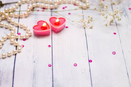 two red burning candles hearts pearls flowersの写真素材