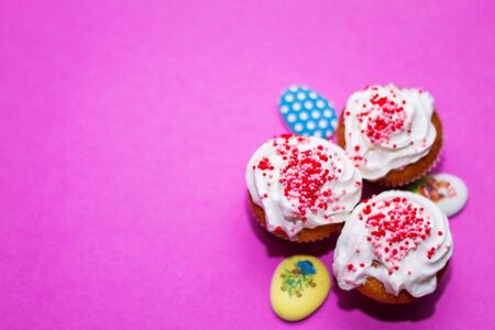 on a pink background close-up of colored Easter eggs and cupcake, holiday backgroundの写真素材