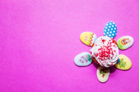 on a pink background close-up of colored Easter eggs and cupcake, holiday backgroundの写真素材